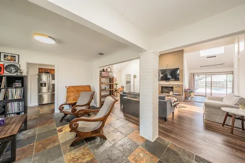 a living room with furniture a large window and wooden floor