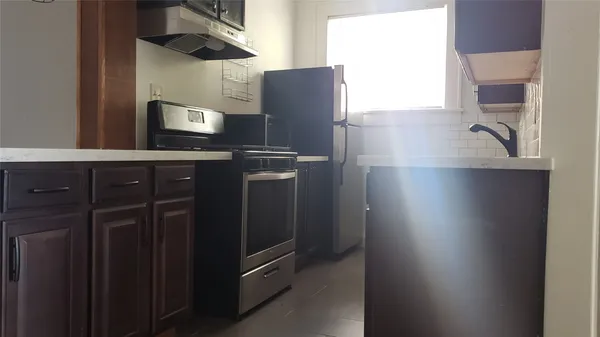 a kitchen with stainless steel appliances granite countertop a refrigerator and a sink