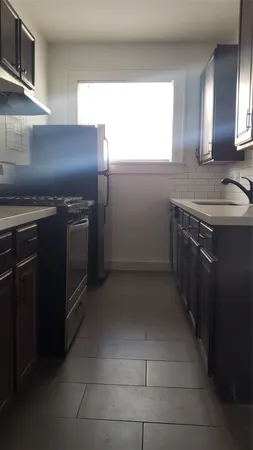 a kitchen with granite countertop a sink and stainless steel appliances