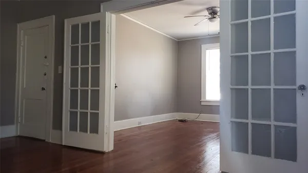 an empty room with wooden floor and windows