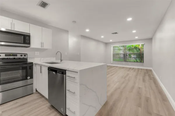 a kitchen with a sink stove and microwave