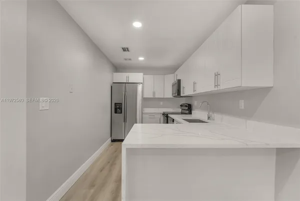 a kitchen with stainless steel appliances a refrigerator sink and cabinets