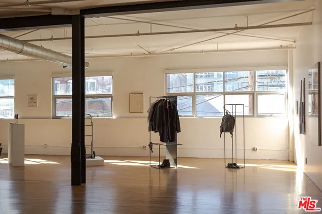 a hallway with wooden floor and windows