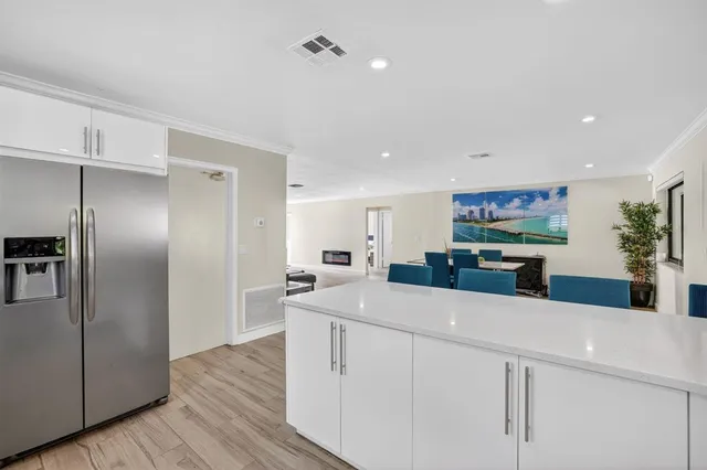 a kitchen with stainless steel appliances kitchen island granite countertop a refrigerator and a sink
