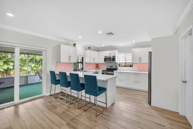 a living room with kitchen island granite countertop furniture and a wooden floor