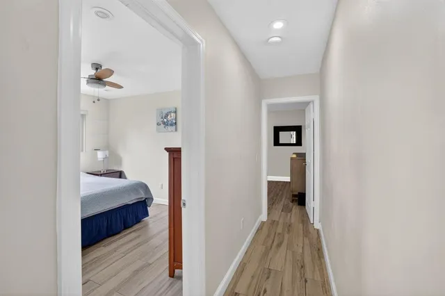 a view of a hallway with wooden floor and closet