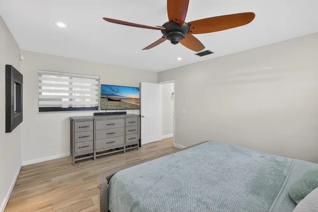 a bedroom with a bed and a ceiling fan