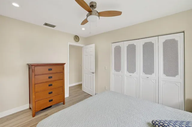 a spacious bedroom with a dresser and a chandelier