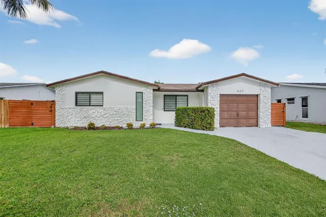 a front view of house with yard and trees