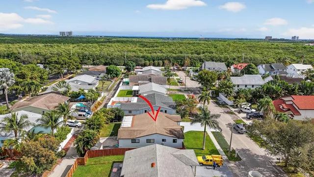 an aerial view of residential houses with outdoor space and trees