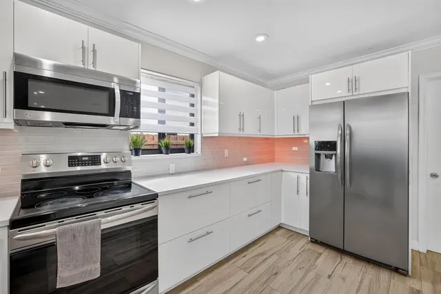 a kitchen with stainless steel appliances a stove microwave and sink