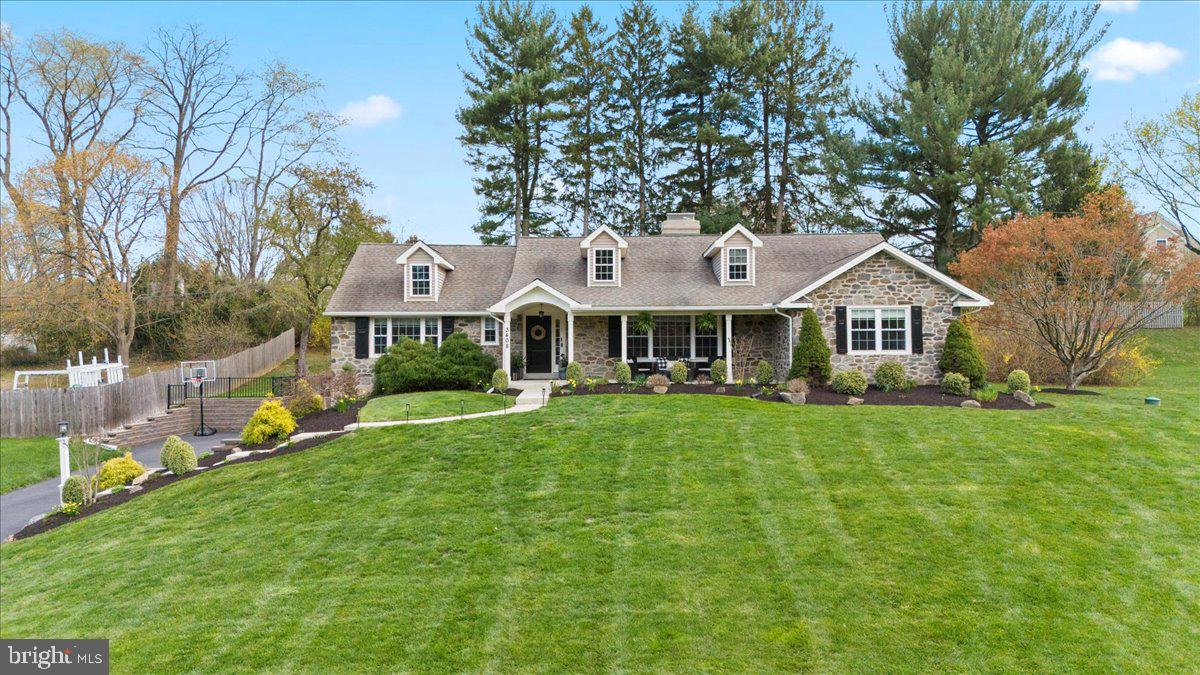 a front view of a house with a yard and trees