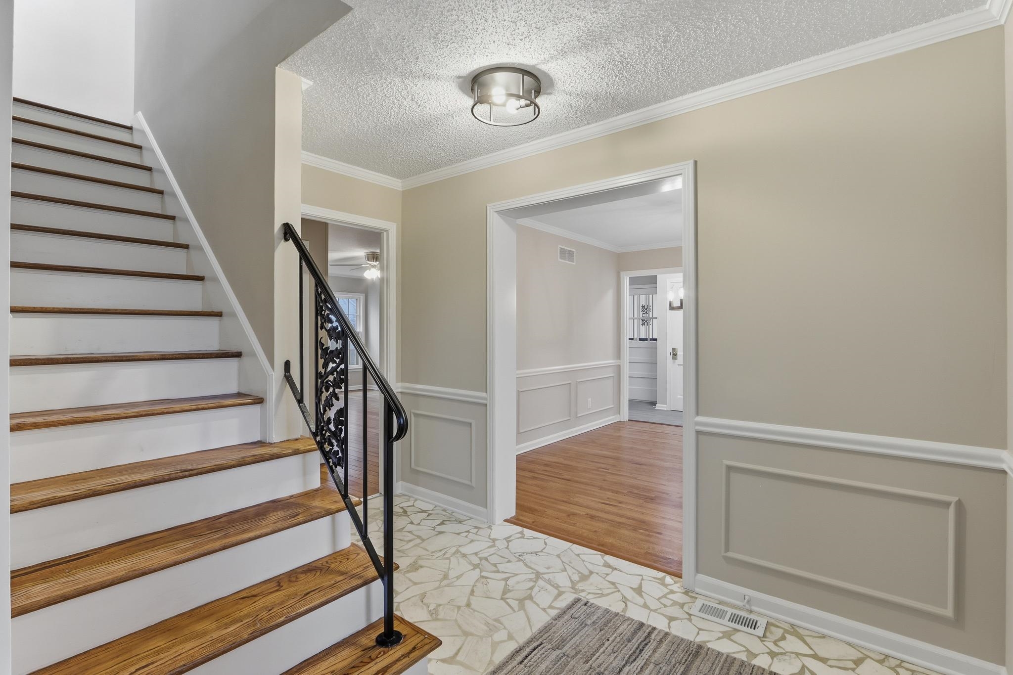 6436 Messick Road Memphis, TN 38119 - Photo 5 of 40 Stairs featuring a decorative wall, wainscoting, crown molding, and a textured ceiling
