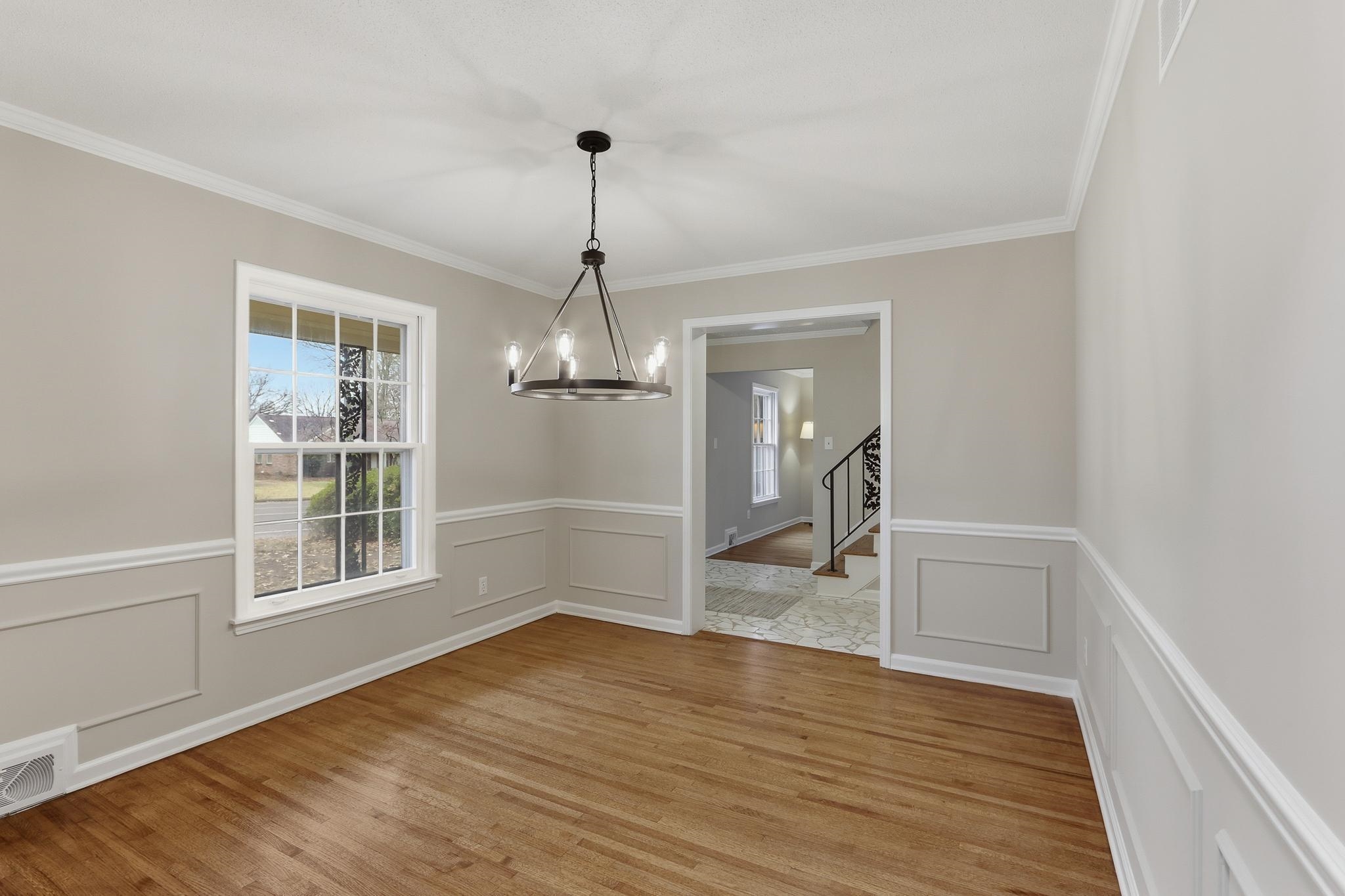 6436 Messick Road Memphis, TN 38119 - Photo 7 of 40 Unfurnished dining area featuring wainscoting, a decorative wall, light wood-type flooring, plenty of natural light, and stairs