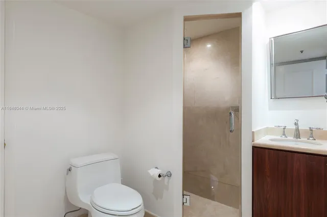 a white toilet sitting next to a bathroom sink