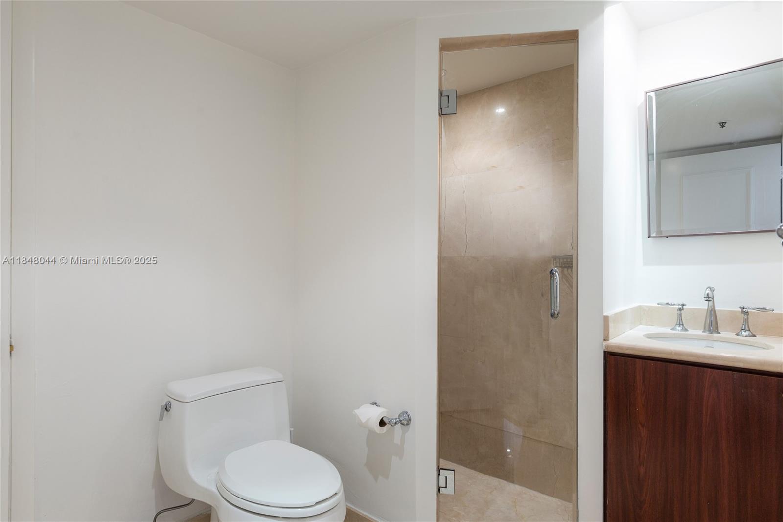251 Crandon Boulevard, Unit 243 Key Biscayne, FL 33149 - Photo 14 of 23 a white toilet sitting next to a bathroom sink