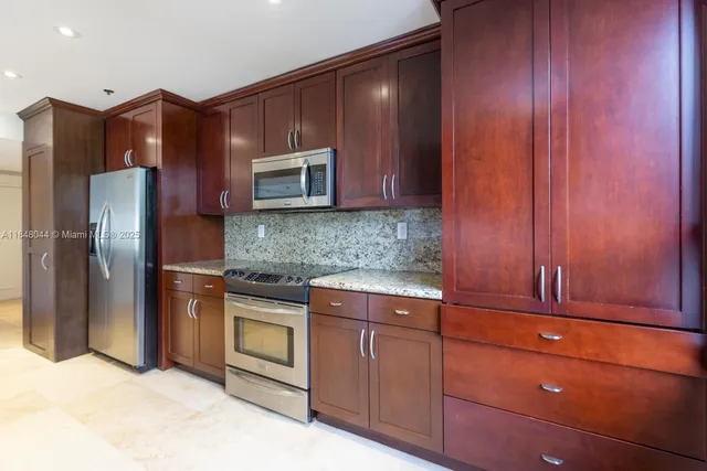 a kitchen with stainless steel appliances granite countertop wooden cabinets a stove top oven a sink and dishwasher