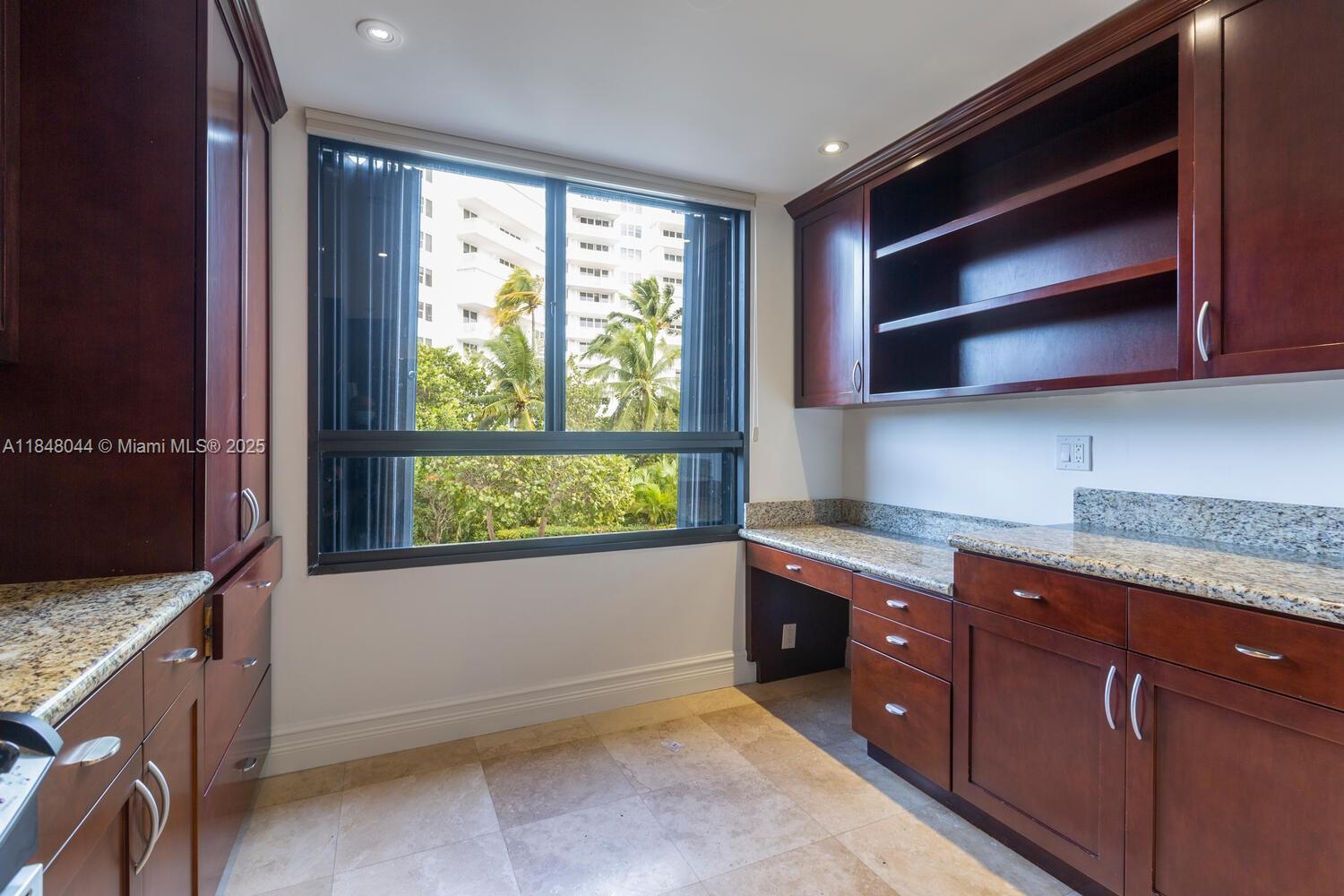 251 Crandon Boulevard, Unit 243 Key Biscayne, FL 33149 - Photo 6 of 23 a kitchen with granite countertop wooden cabinets and a sink