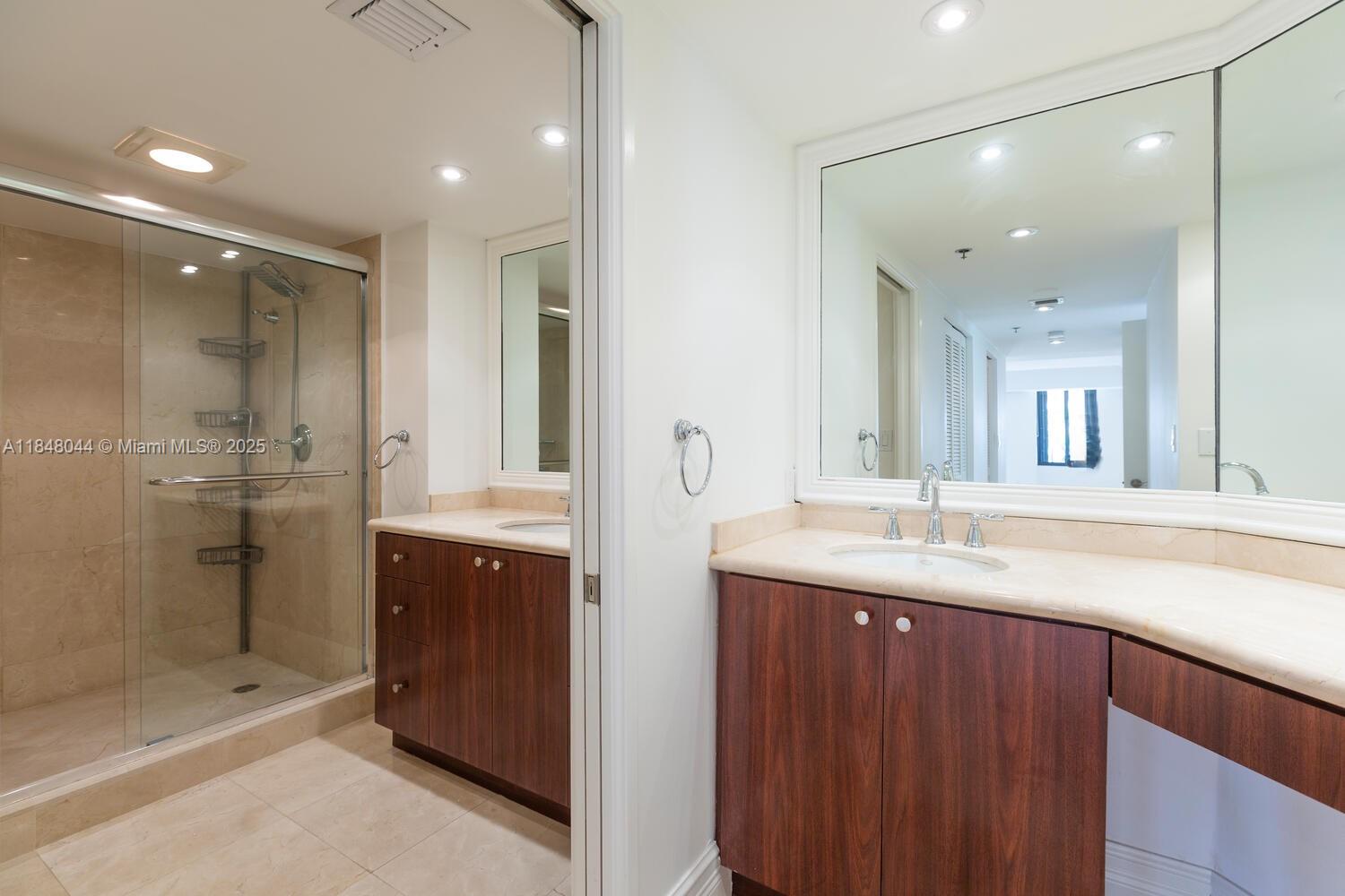 251 Crandon Boulevard, Unit 243 Key Biscayne, FL 33149 - Photo 10 of 23 a bathroom with a shower sink double and mirror