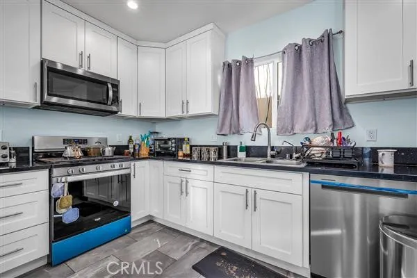 a kitchen with white cabinets and a sink