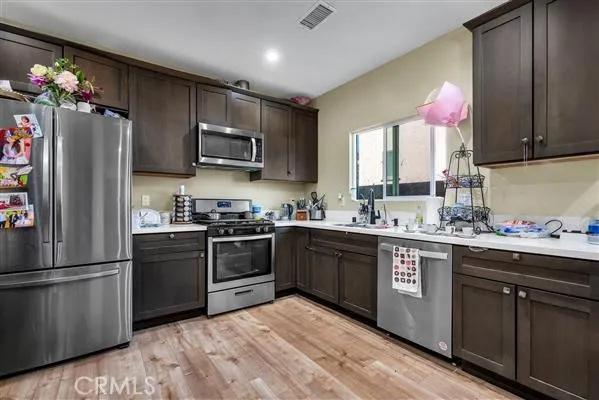 a kitchen with granite countertop stainless steel appliances a sink cabinets and a counter top space
