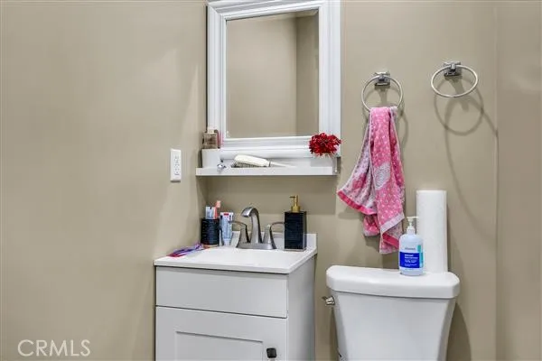 a bathroom with a sink vanity mirror and toilet