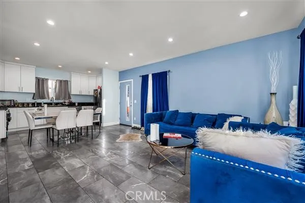 a living room with stainless steel appliances kitchen island granite countertop furniture and a view of kitchen