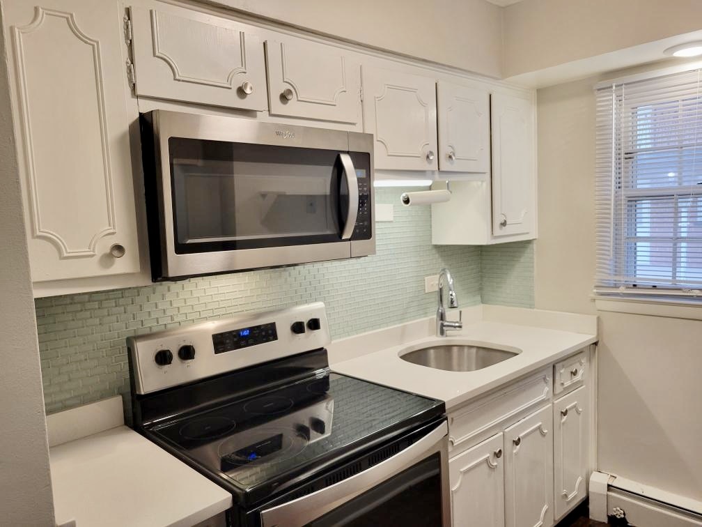 6046 West Pershing Road, Unit 4 Cicero, IL 60804 - Photo 6 of 8 a kitchen with stainless steel appliances granite countertop a sink stove and microwave