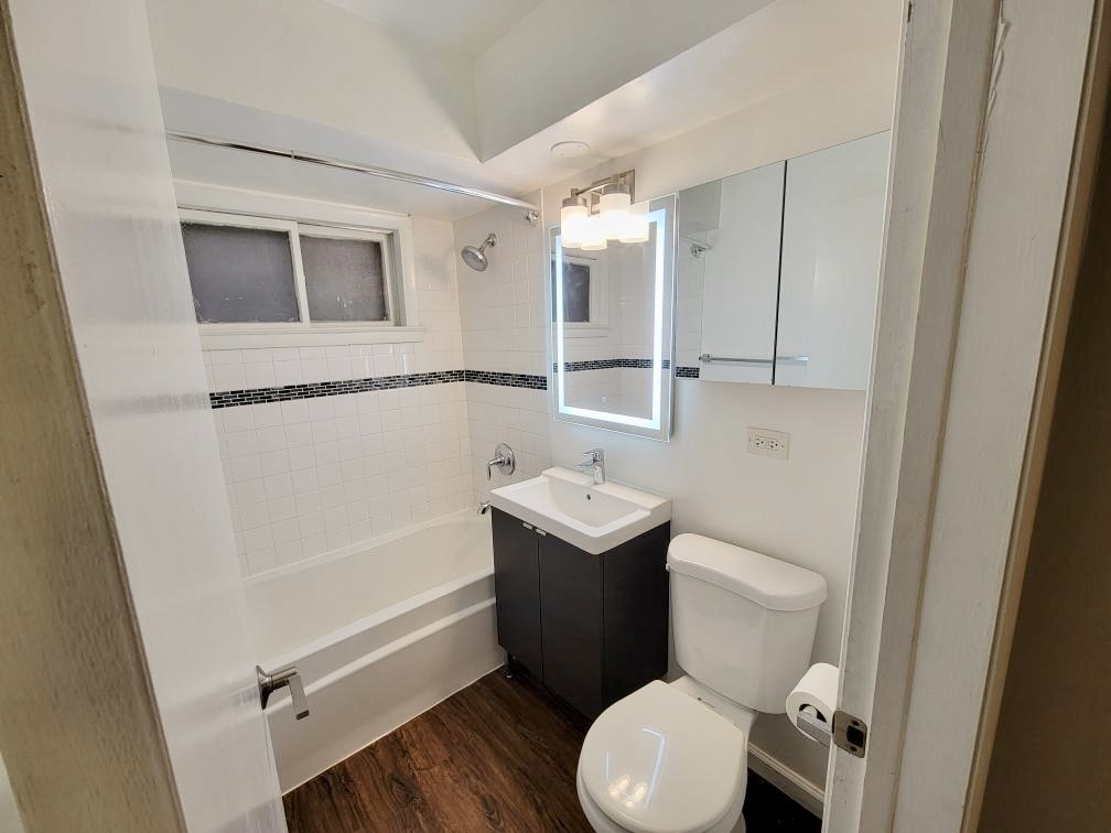 6046 West Pershing Road, Unit 4 Cicero, IL 60804 - Photo 7 of 8 a bathroom with a toilet sink and mirror