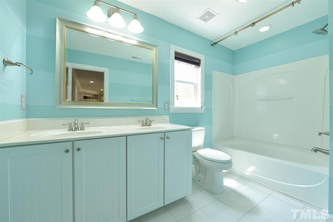 13015 Saxon Way Raleigh, NC 27613 - Photo 23 of 30 a bathroom with a toilet sink and mirror