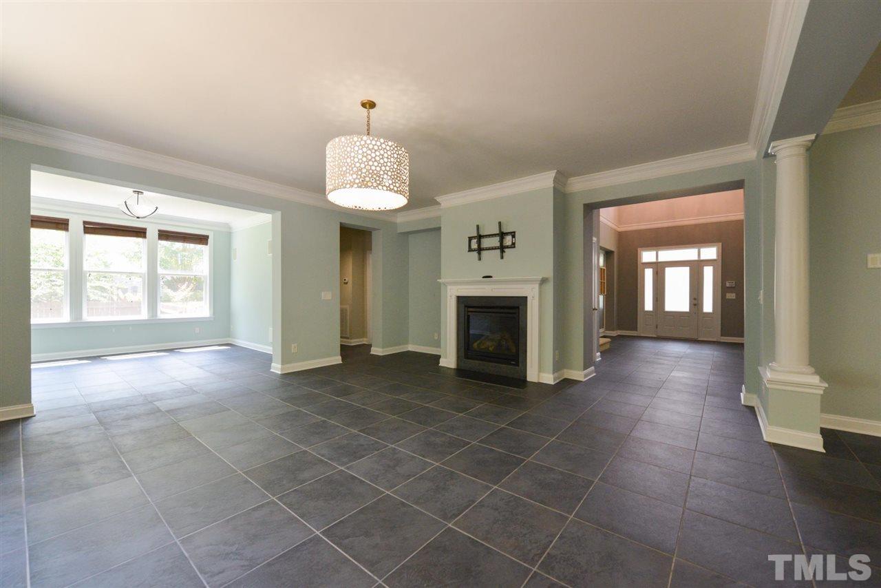 13015 Saxon Way Raleigh, NC 27613 - Photo 6 of 30 an empty room with fireplace and windows