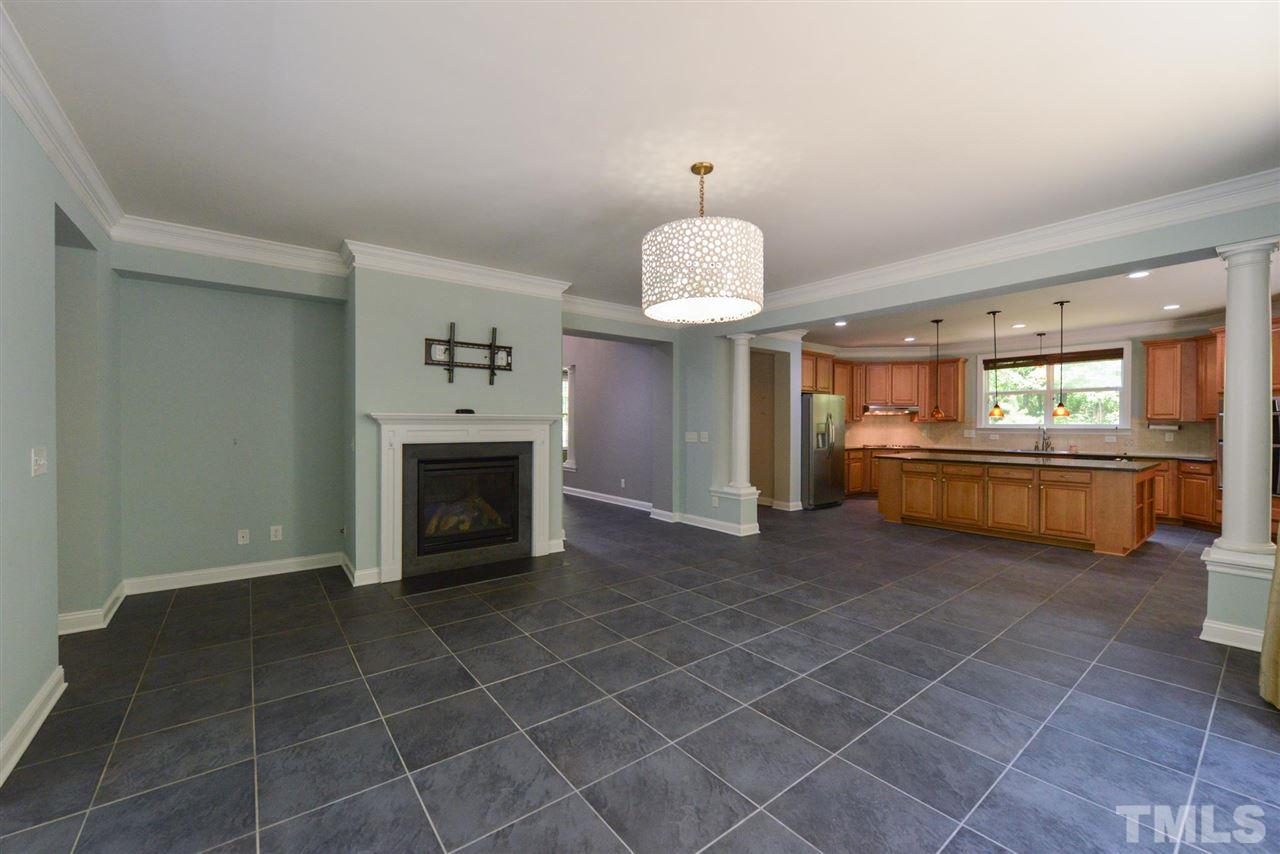 13015 Saxon Way Raleigh, NC 27613 - Photo 8 of 30 a view of an empty room and kitchen with fireplace cabinet