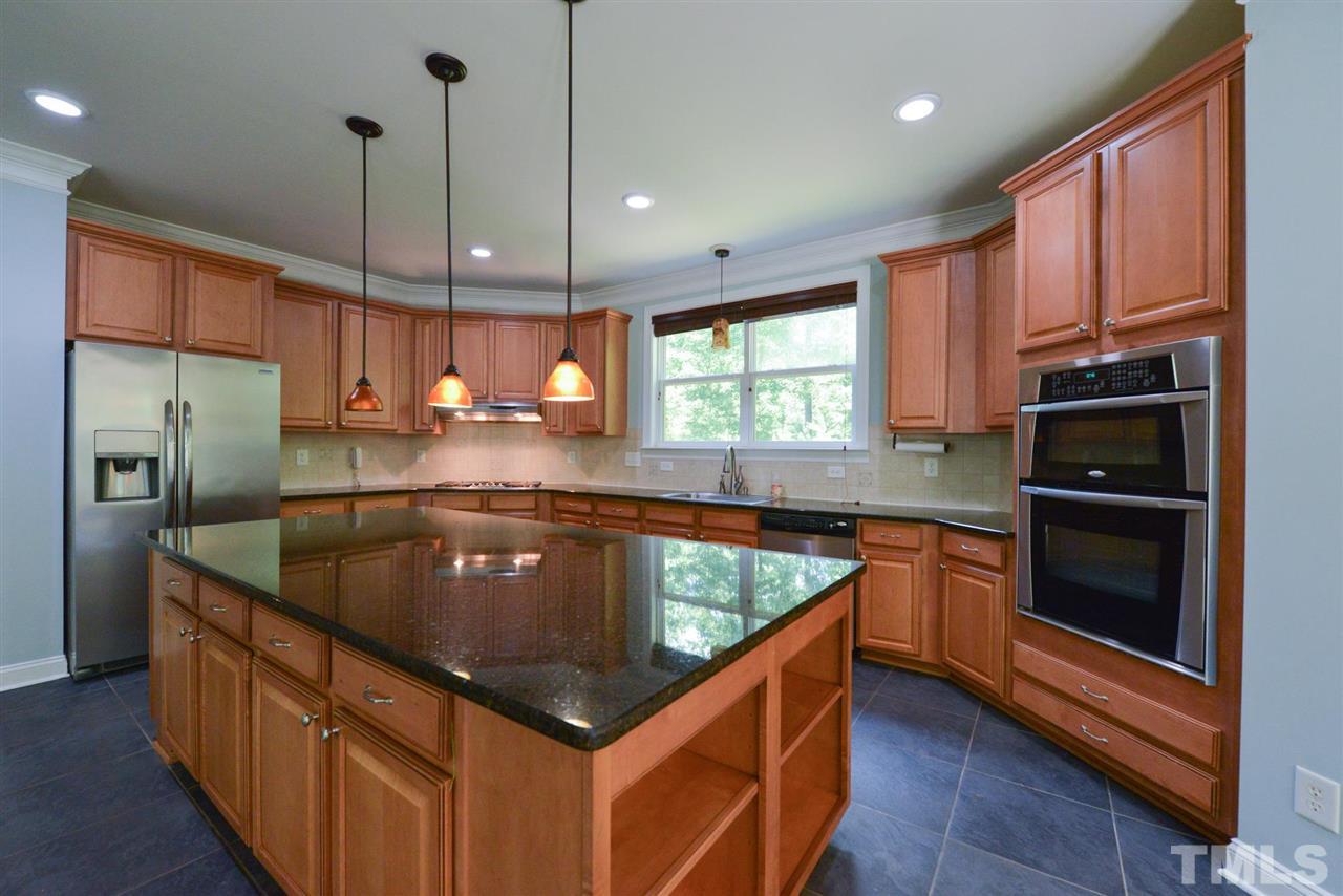 13015 Saxon Way Raleigh, NC 27613 - Photo 10 of 30 a kitchen with stainless steel appliances granite countertop a sink a stove a refrigerator a sink a stove and island with wooden floor