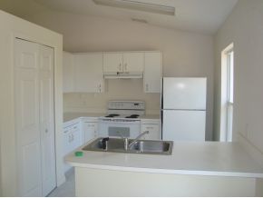 1836 Northeast Cleveland Palm Bay, FL 32905 - Photo 4 of 7 a kitchen with a sink a stove and white cabinets