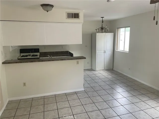 an empty room with kitchen view