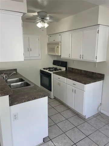 a kitchen with a stove sink and cabinets