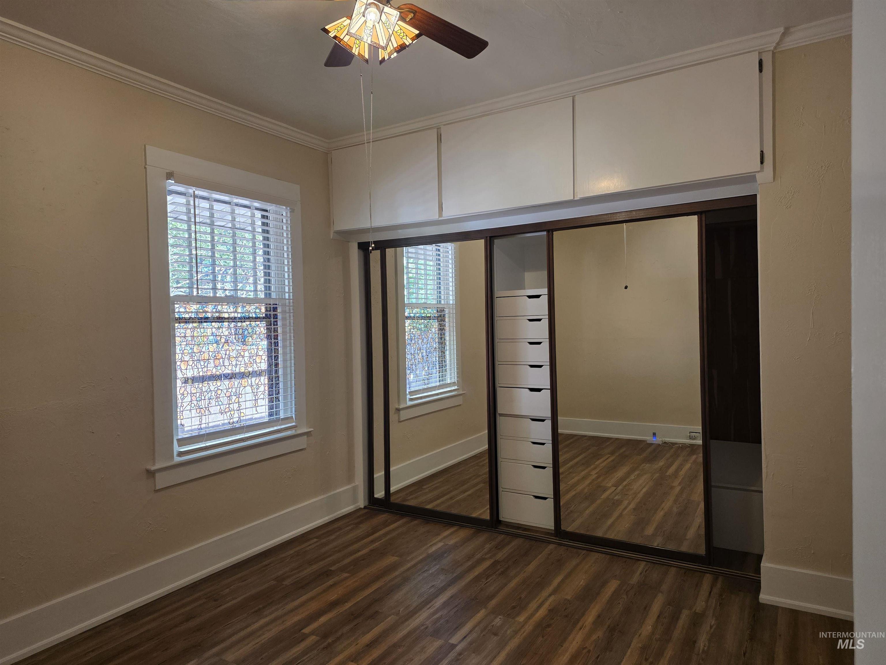 421 East Main Street Jerome, ID 83338 - Photo 7 of 13 Room featuring wood-finish flooring, a window with horizontal blinds, and a ceiling fan with an amber-toned light fixture