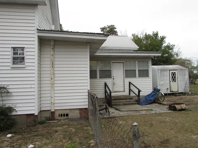 a view of a patio with table and chairs and wooden fence