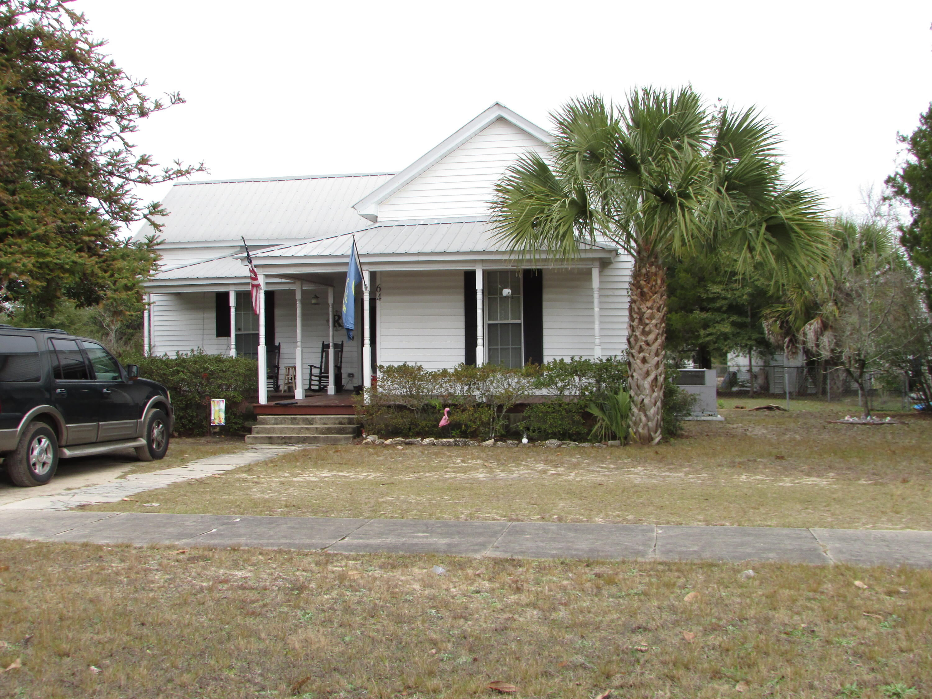 64 Live Oak Avenue West DeFuniak Springs, FL 32435 - Photo 16 of 20 a view of a house with backyard porch and sitting area