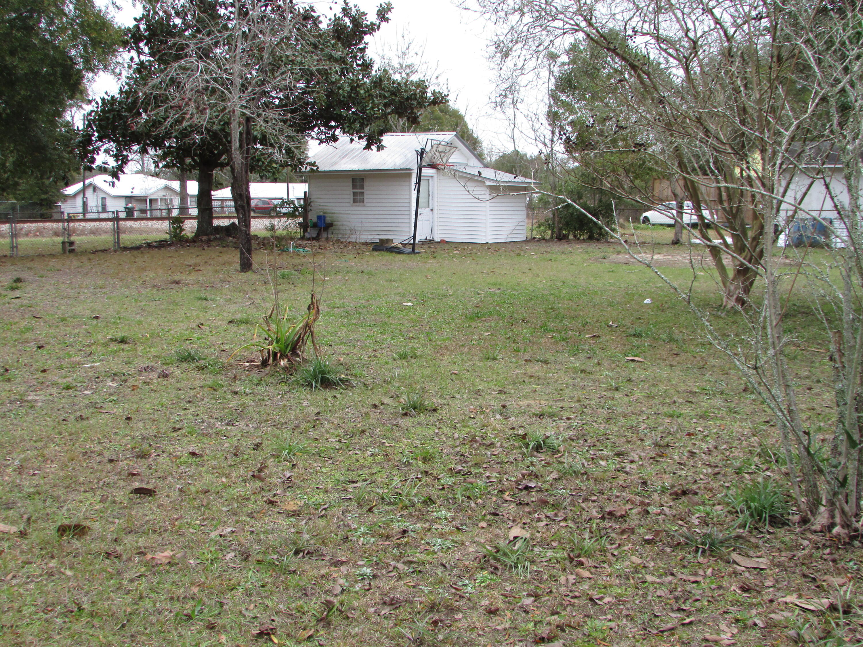 64 Live Oak Avenue West DeFuniak Springs, FL 32435 - Photo 19 of 20 a white house that has a tree in front of it
