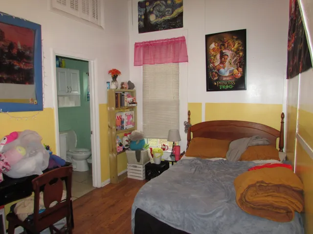 a bedroom with a bed and wooden floor