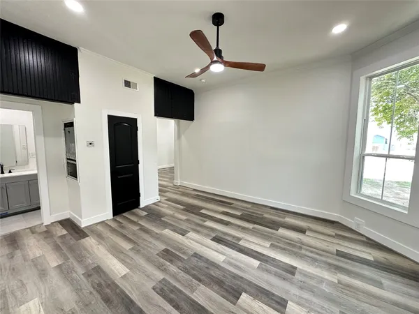 a view of empty room with window and ceiling fan