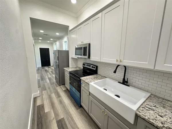 a kitchen with a sink stove and microwave