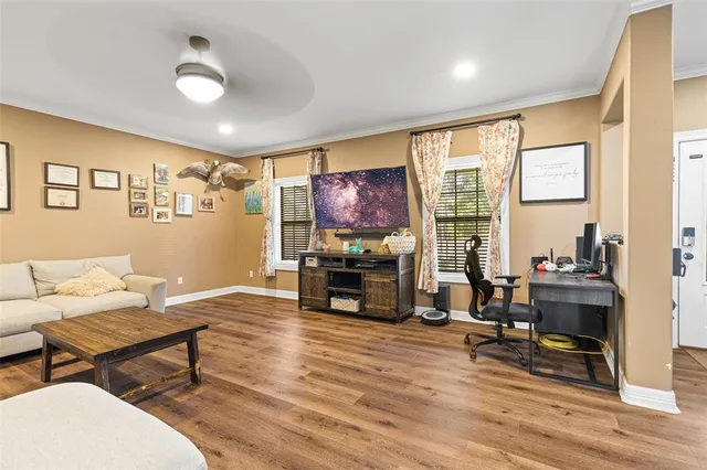 a living room with furniture and a flat screen tv with wooden floor
