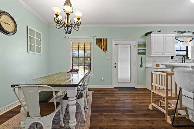 a view of a dining room with furniture and chandelier