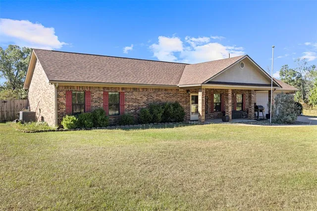 a front view of a house with a yard and outdoor seating