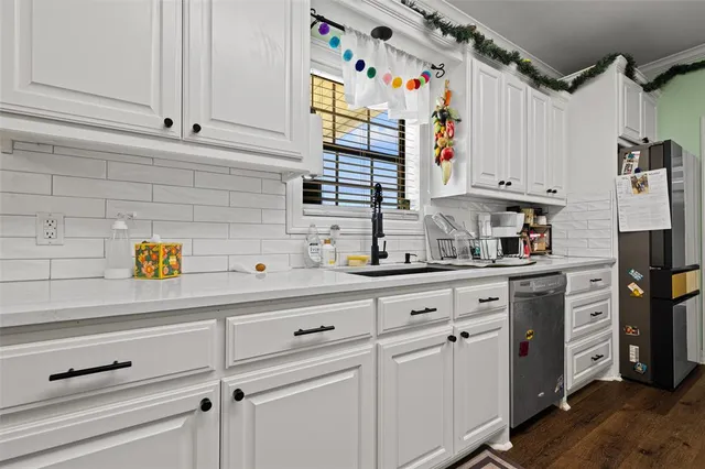 a kitchen with stainless steel appliances white cabinets and a refrigerator