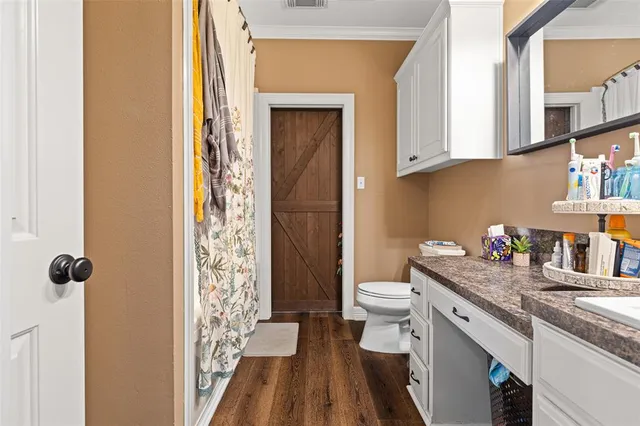 a bathroom with a granite countertop sink a toilet and shower