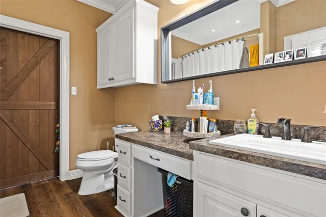 a bathroom with a granite countertop sink a toilet and a mirror