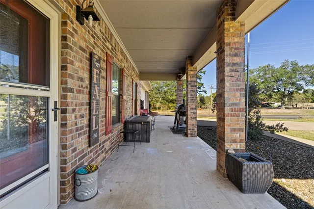 a porch with table and chairs and potted plants